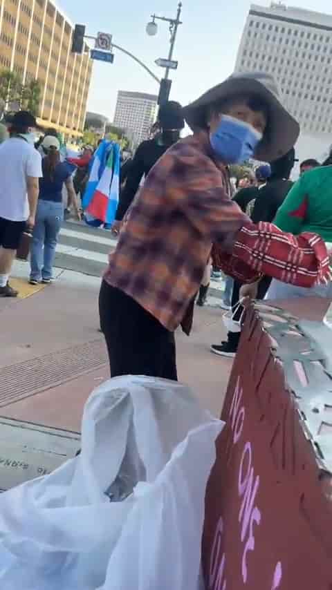 Elderly lady is doing her best to clean up during the protests