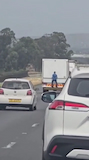 Man free riding on back of truck on highway loses his grip thumbnail